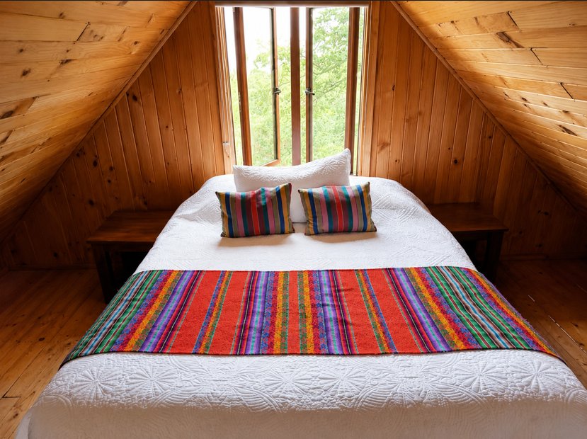 Dormitorio en altillo de la Cabaña Chercán con textiles de inspiración mapuche